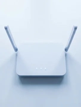 Moderne draadloze router met symmetrische antennes en blauwe LED-indicatoren op witte bureau, minimalistisch design