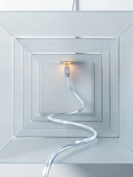 Ethernet-kabel met glasvezel-elementen door geometrische tunnel van matglas panelen met amber verlichting