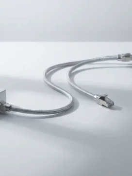 Zilveren ethernetkabel verbindt twee moderne netwerkapparaten met blauwe LED-indicatoren op wit bureau