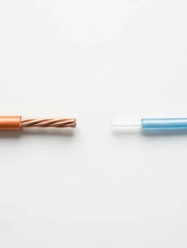 Koperen kabel en glasvezelkabel liggen parallel op witte ondergrond, met zichtbare gedraaide draden en transparante glasvezelkern