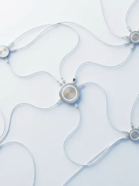 Netwerk van witte ethernet kabels verbonden met zilveren aansluitpunten die zacht blauw licht uitstralen op witte ondergrond
